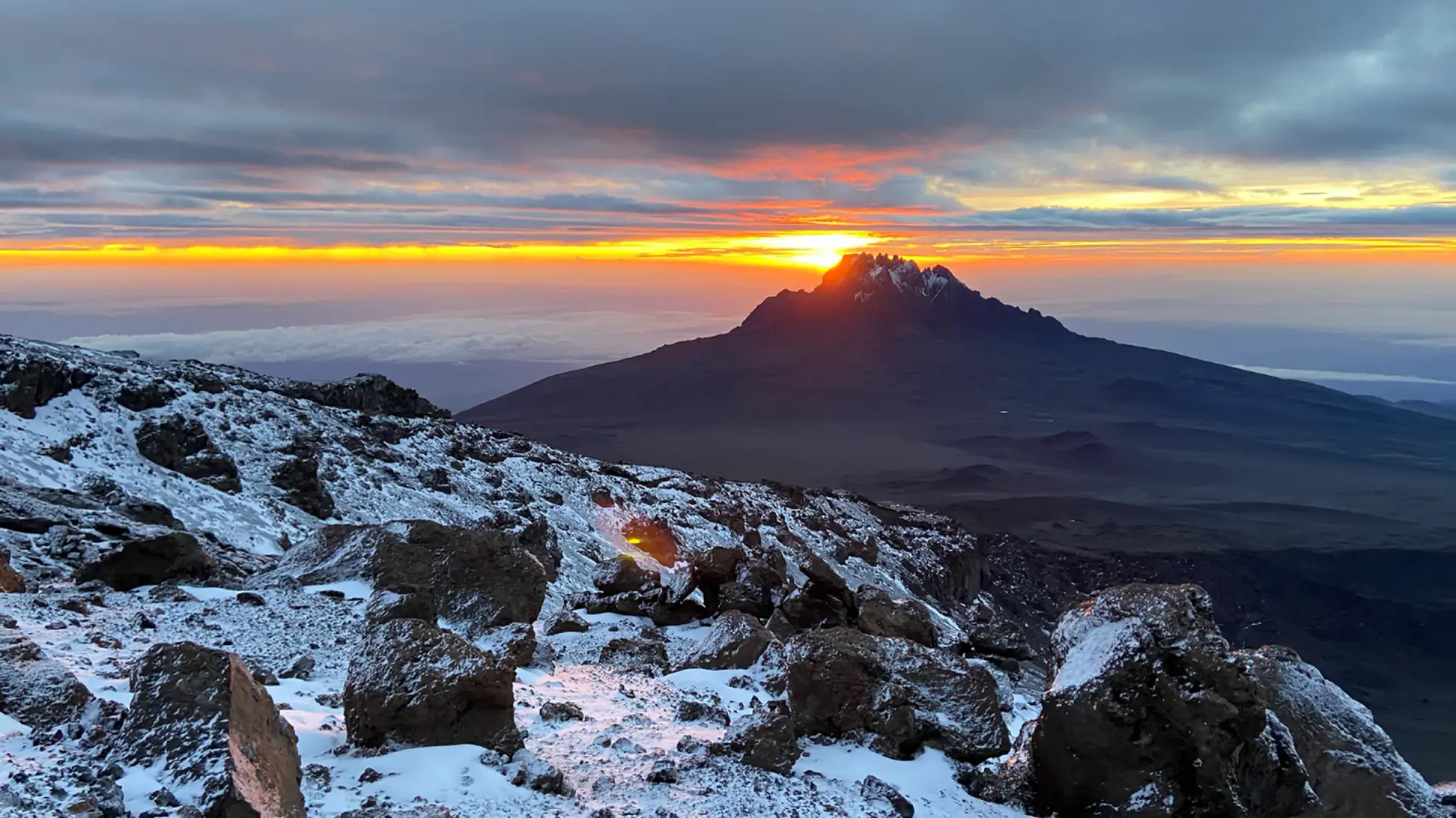 Sunrise above the clouds from the snowy upper slopes of Kilimanjaro
