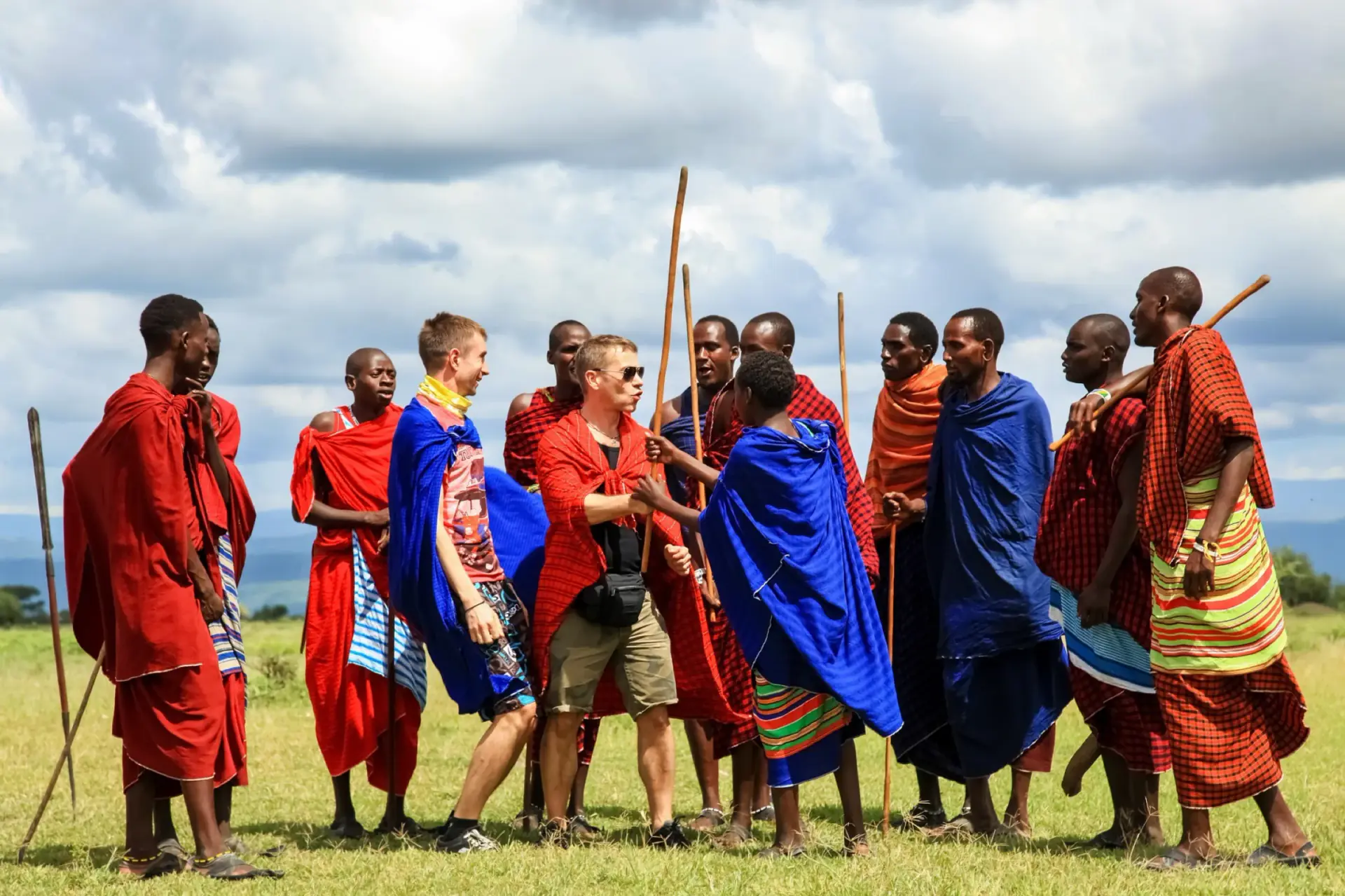 Guests standing with Maasai warriors in red and blue shukas