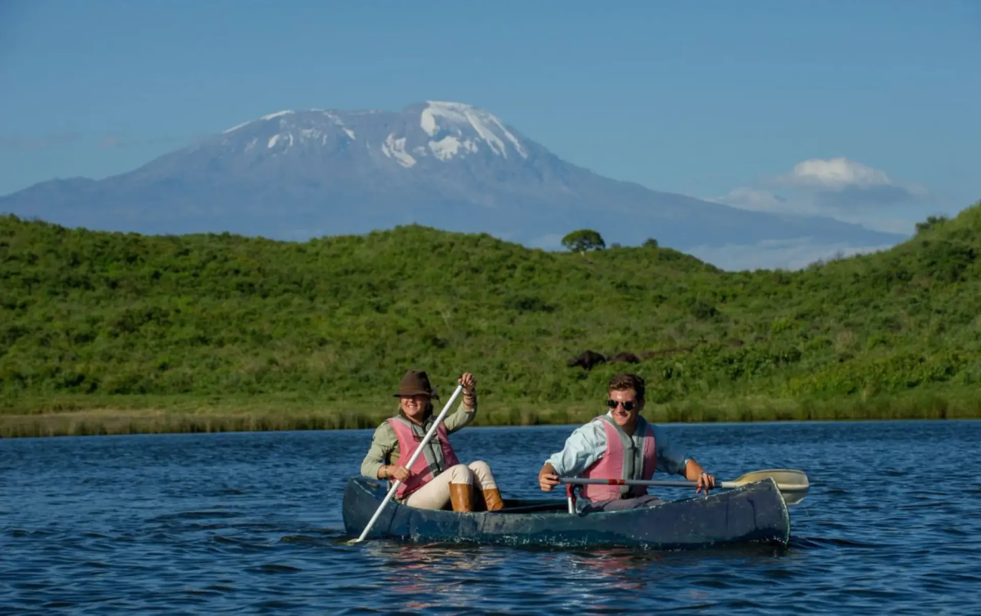 Couple canoeing on a lake with Mount Kilimanjaro behind them