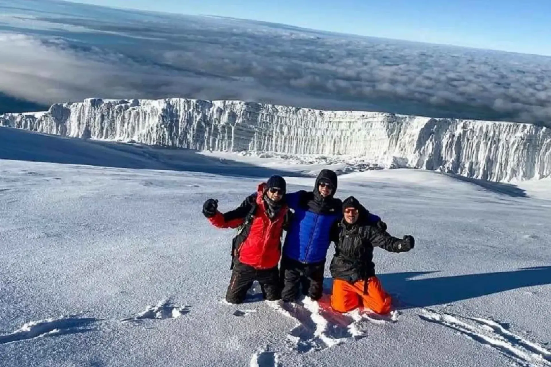 Climbers celebrating in the snow below a Kilimanjaro glacier