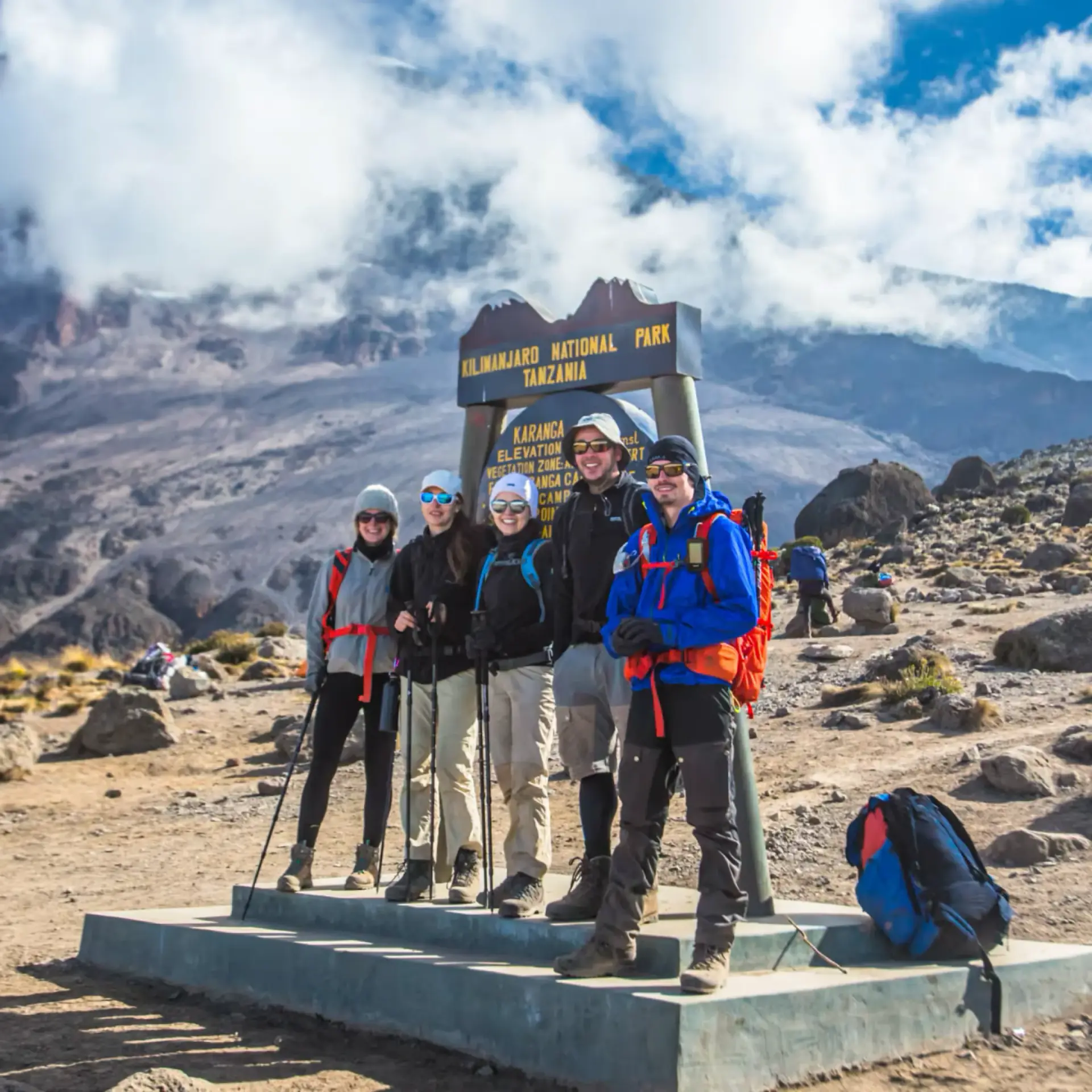 Climbers posing at a Kilimanjaro National Park sign