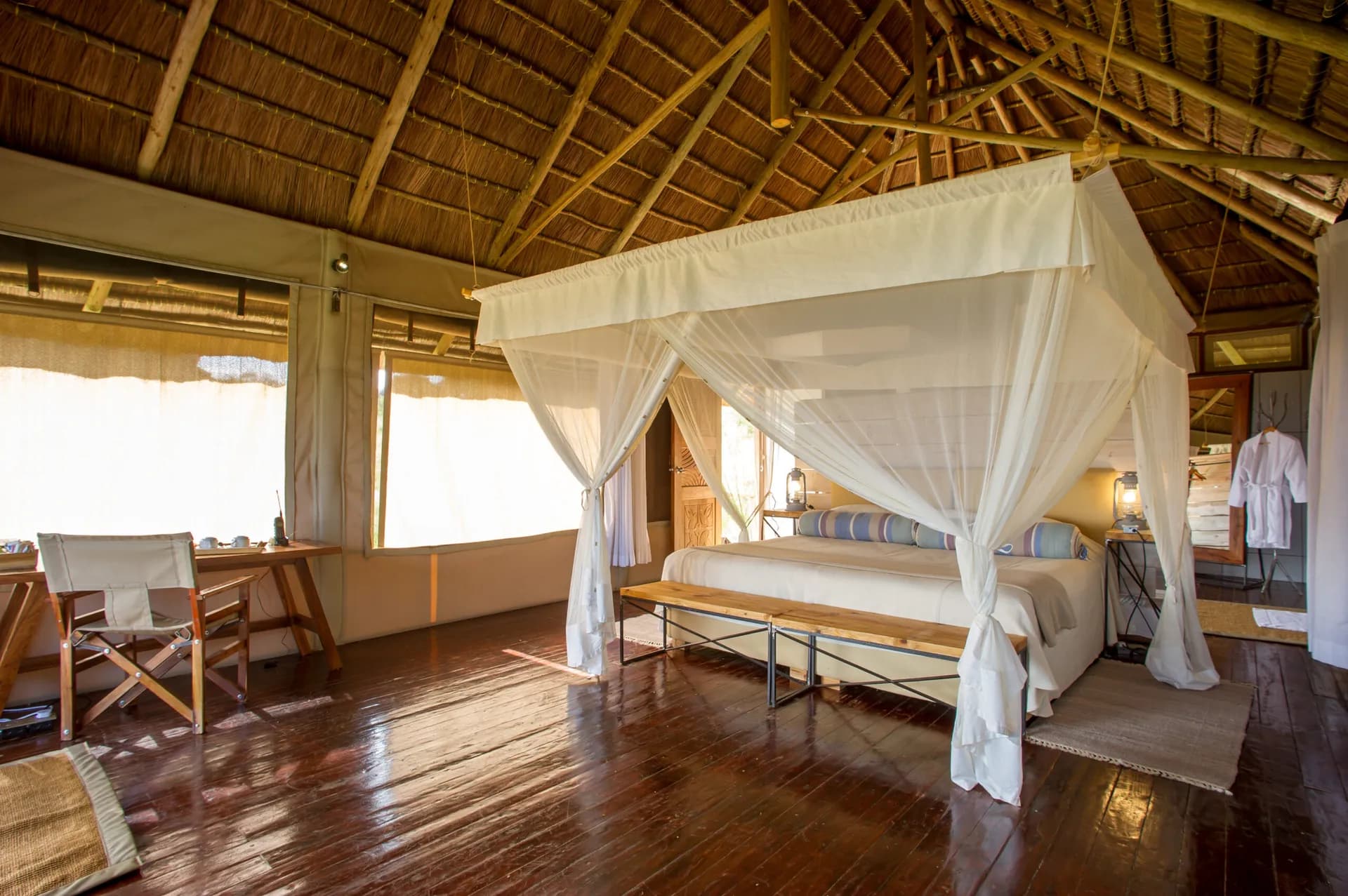 Kubu Kubu suite in daylight, sun coming through the canvas walls onto a canopy bed
