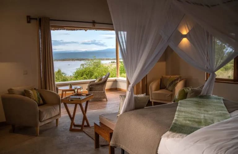Villa bedroom at Manyara's Secret with a canopy bed and an open view over Lake Manyara