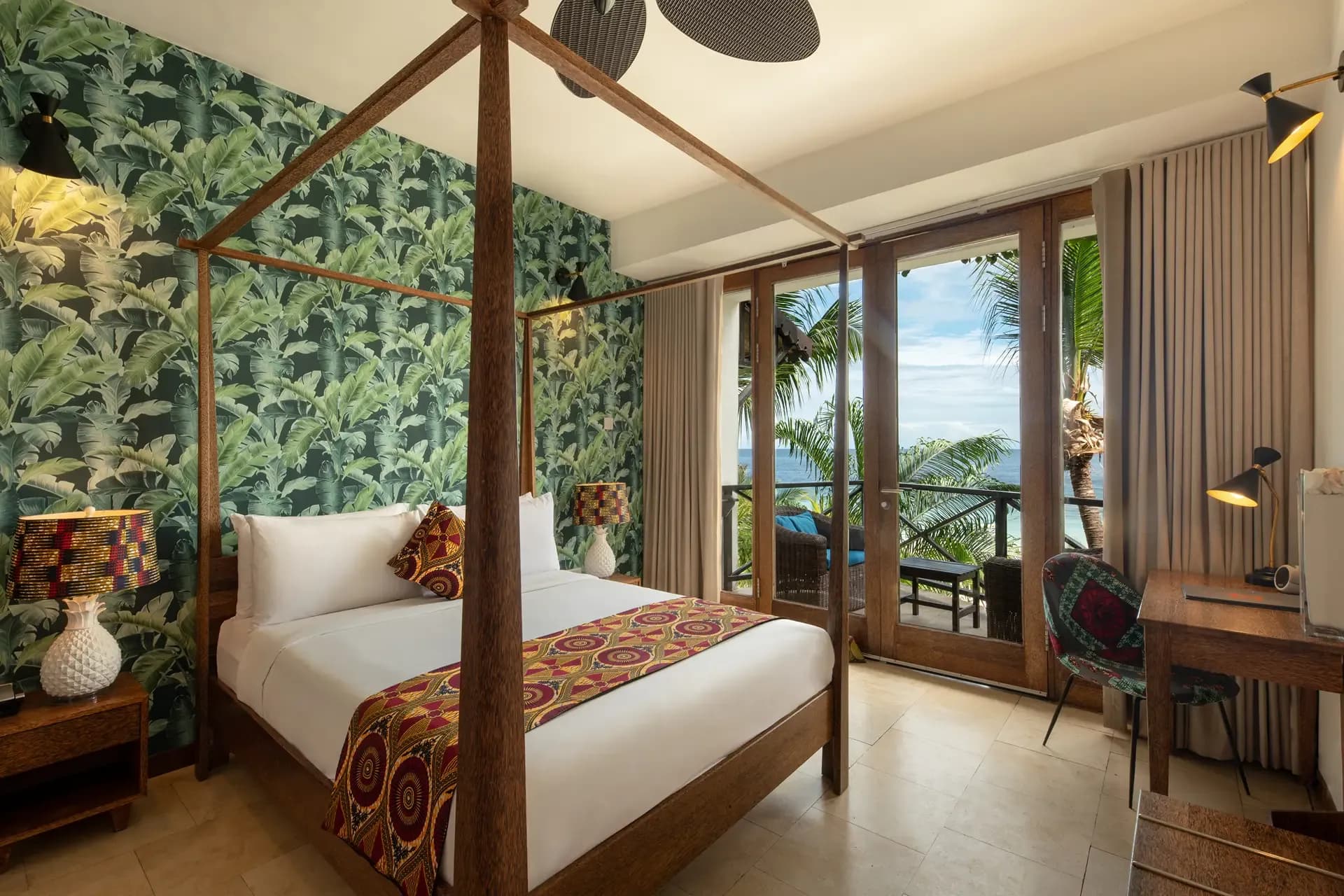Four-poster bed at Z Hotel, Nungwi, with doors open to a balcony over the Indian Ocean