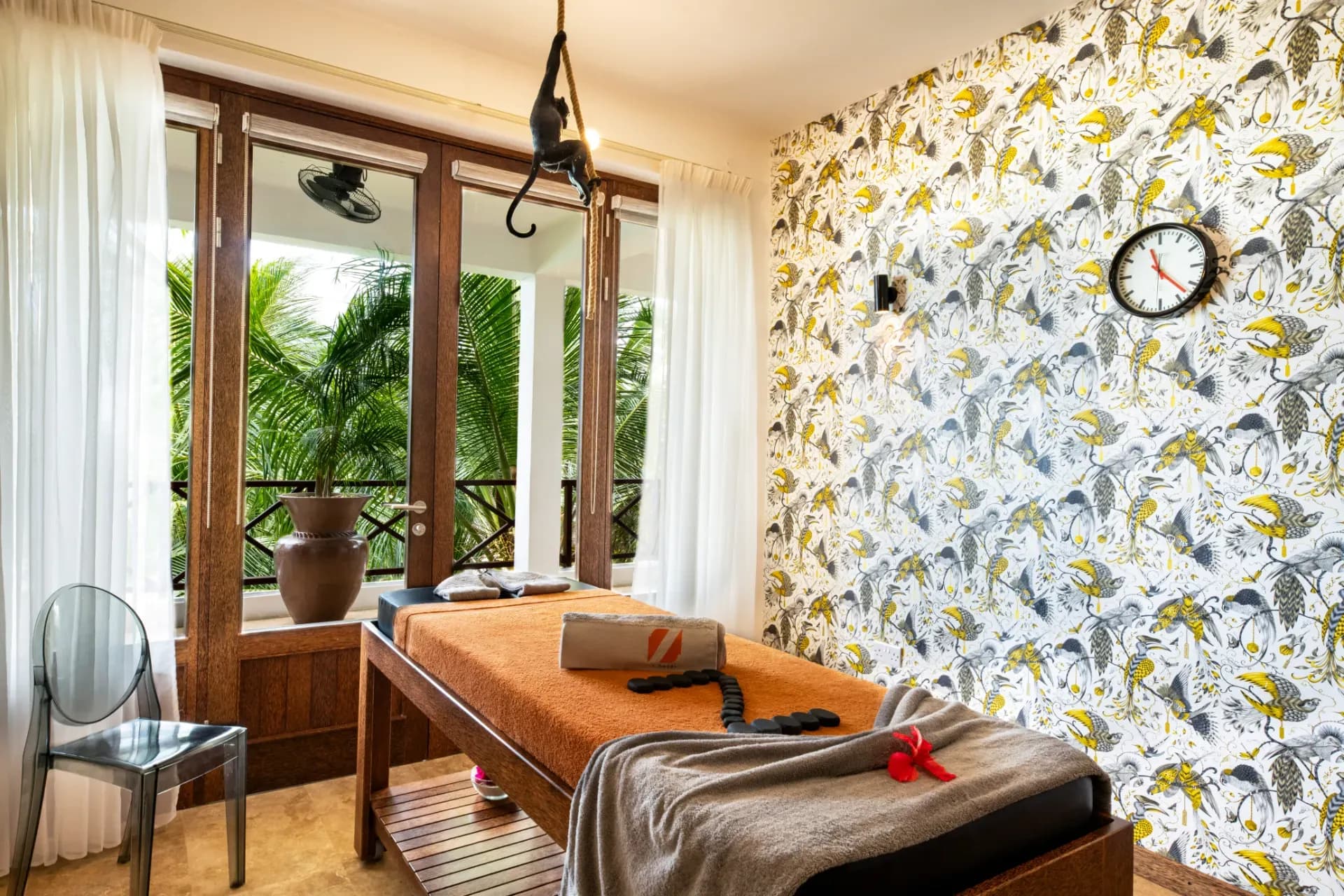 Spa treatment room at Z Hotel with hot stones on the massage bed and palms outside