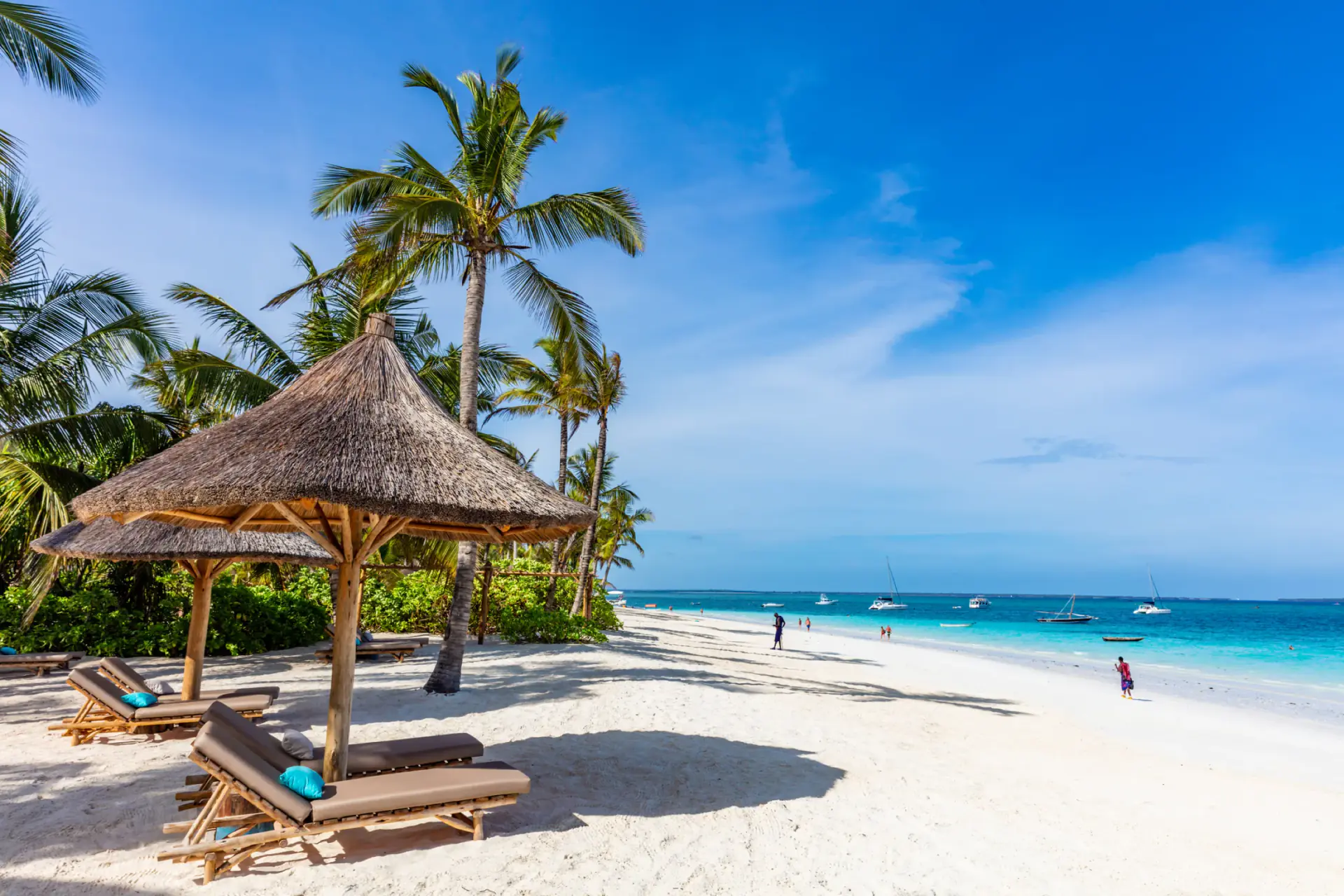 Sun loungers under thatched umbrellas on a Zanzibar beach