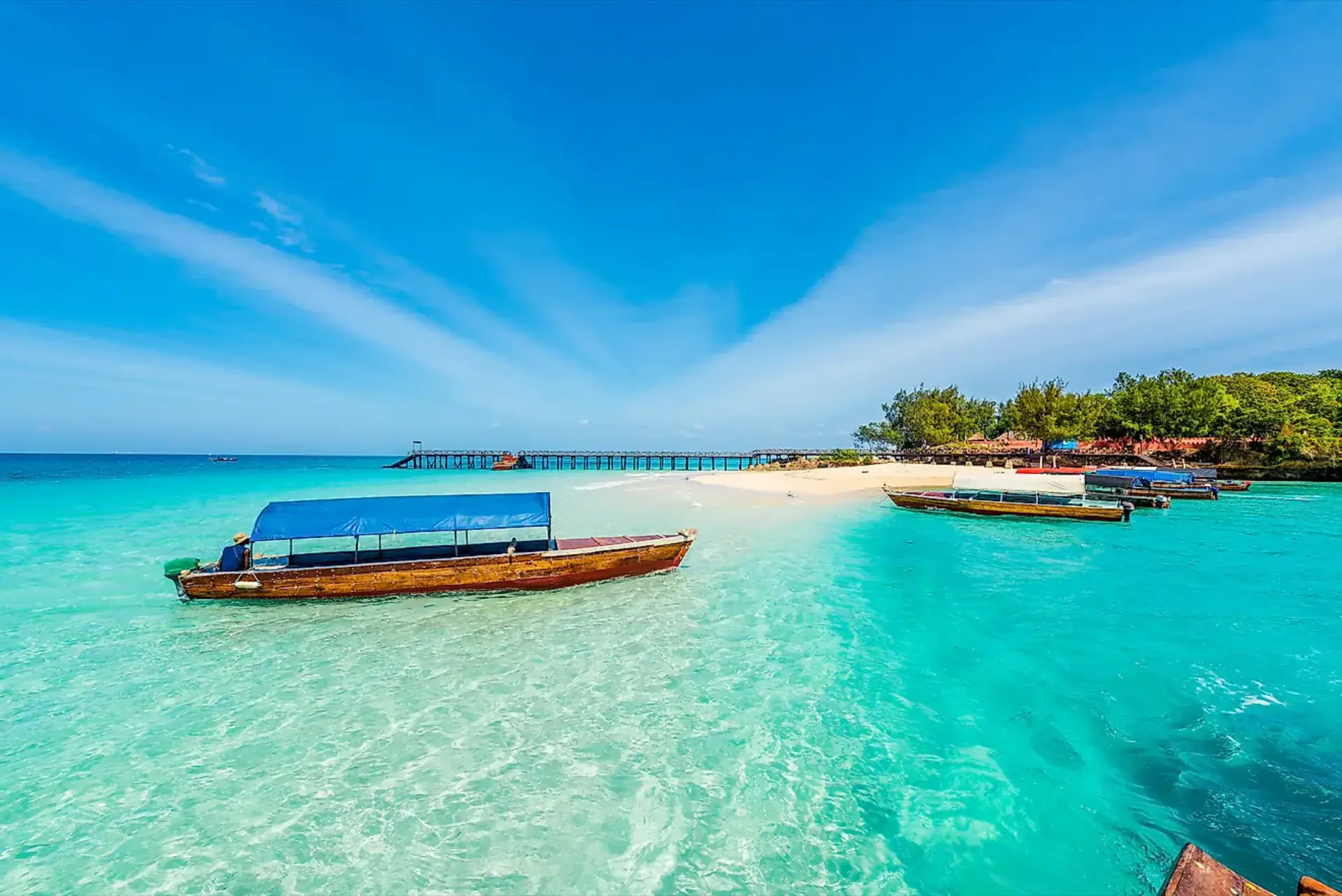 Boats moored in turquoise water off a Zanzibar beach