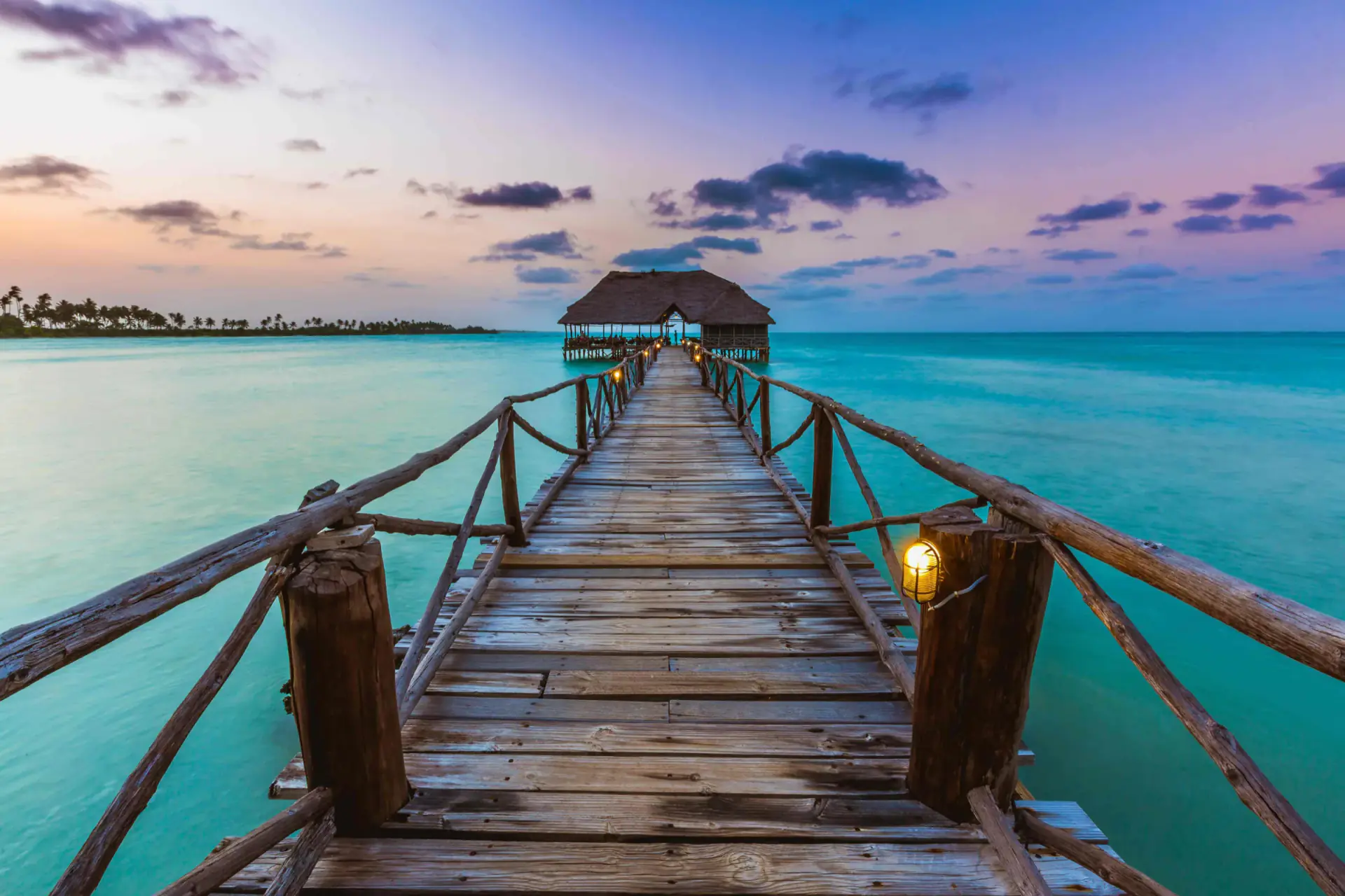 Wooden jetty leading out over the sea at sunset in Zanzibar
